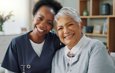 Caregiver and elderly woman smiling together.